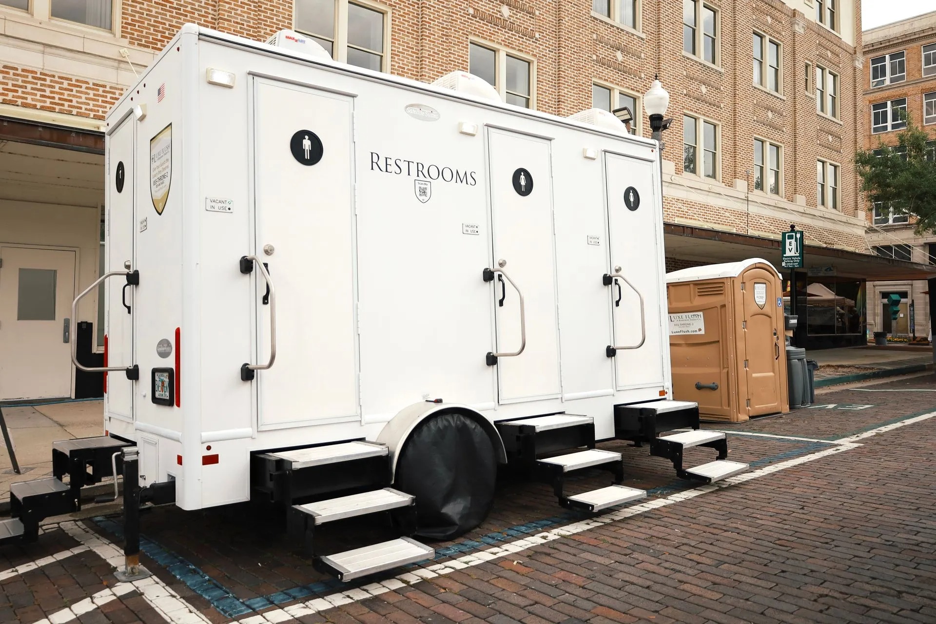 Luxe Flush restroom trailer and service truck staged at a job site